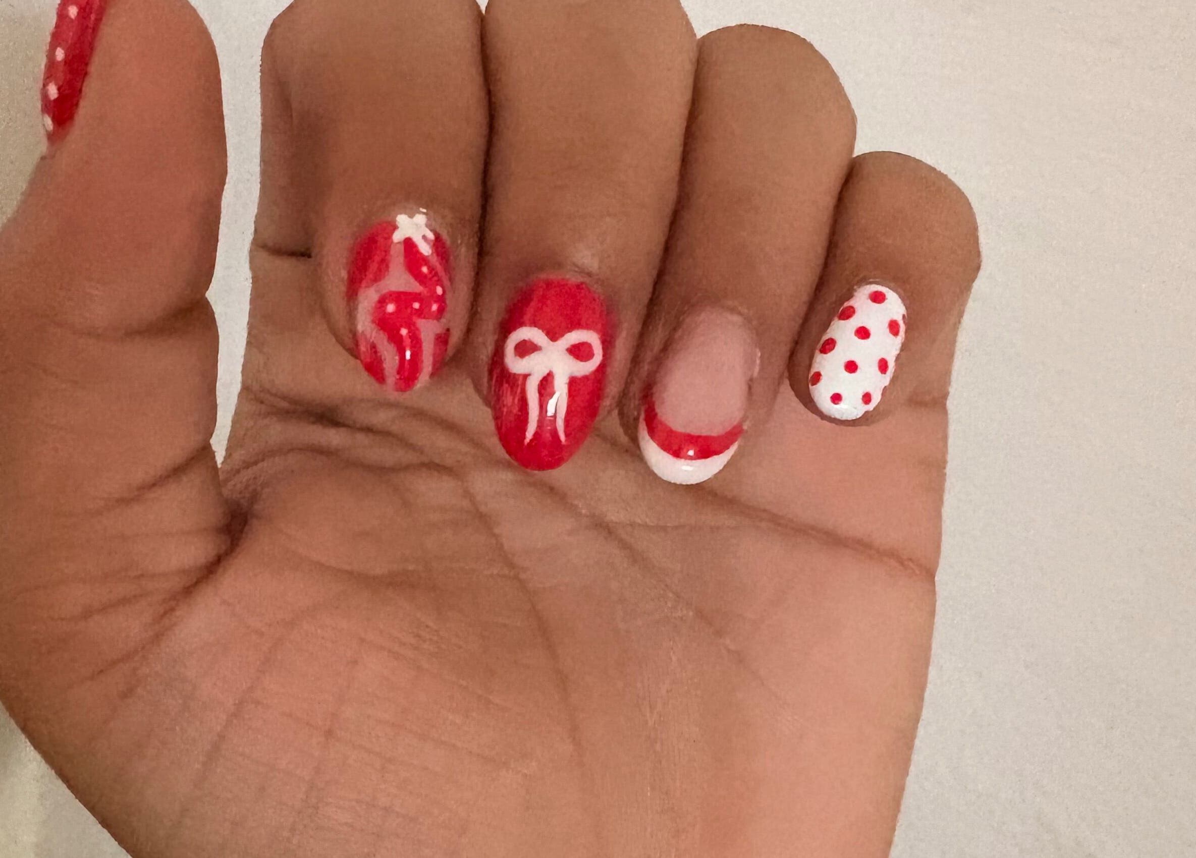 Red and white festive nail art at The Claw Club in Prince Edward, Ontario, CA.