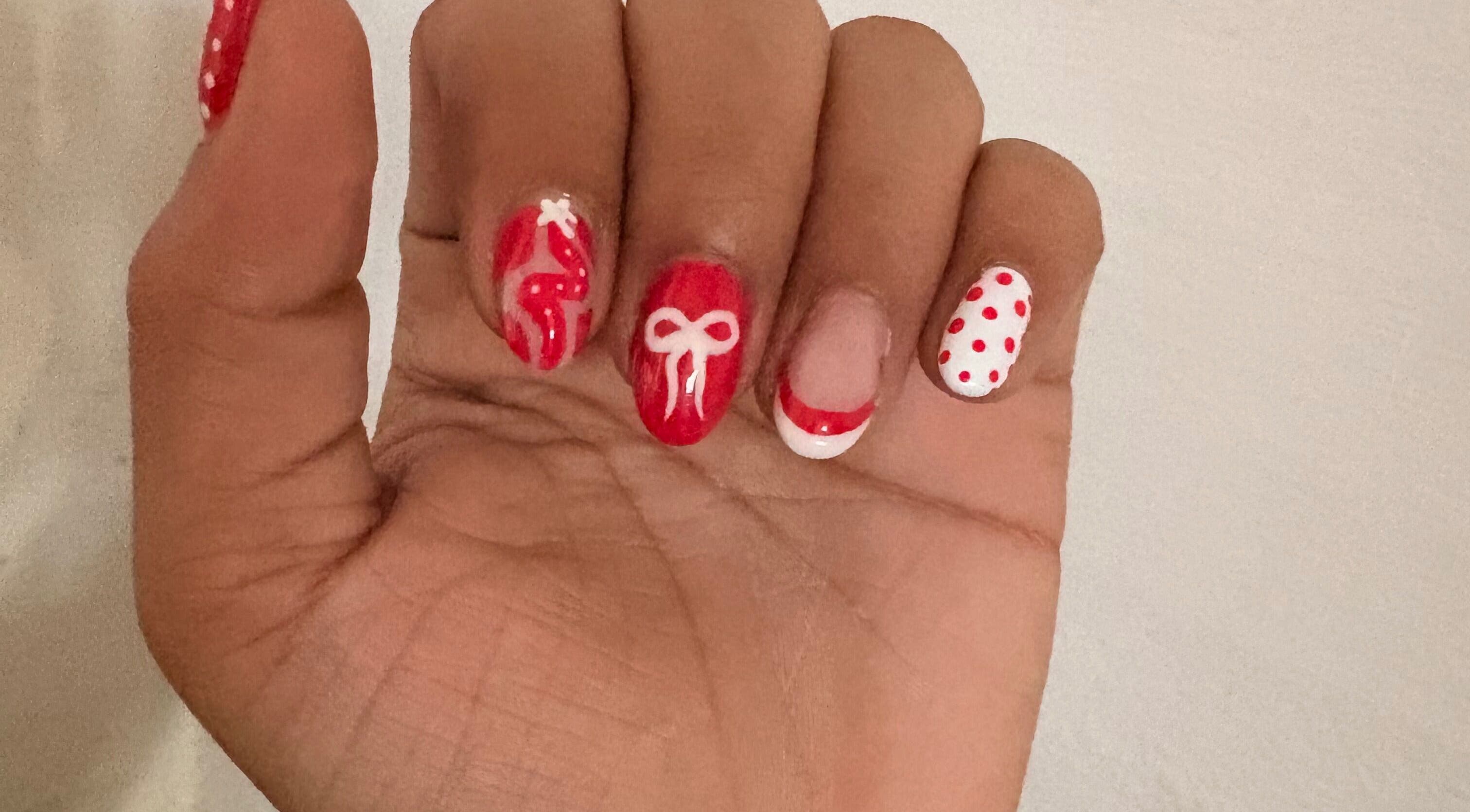 Red and white festive nail art at The Claw Club in Prince Edward, Ontario, CA.