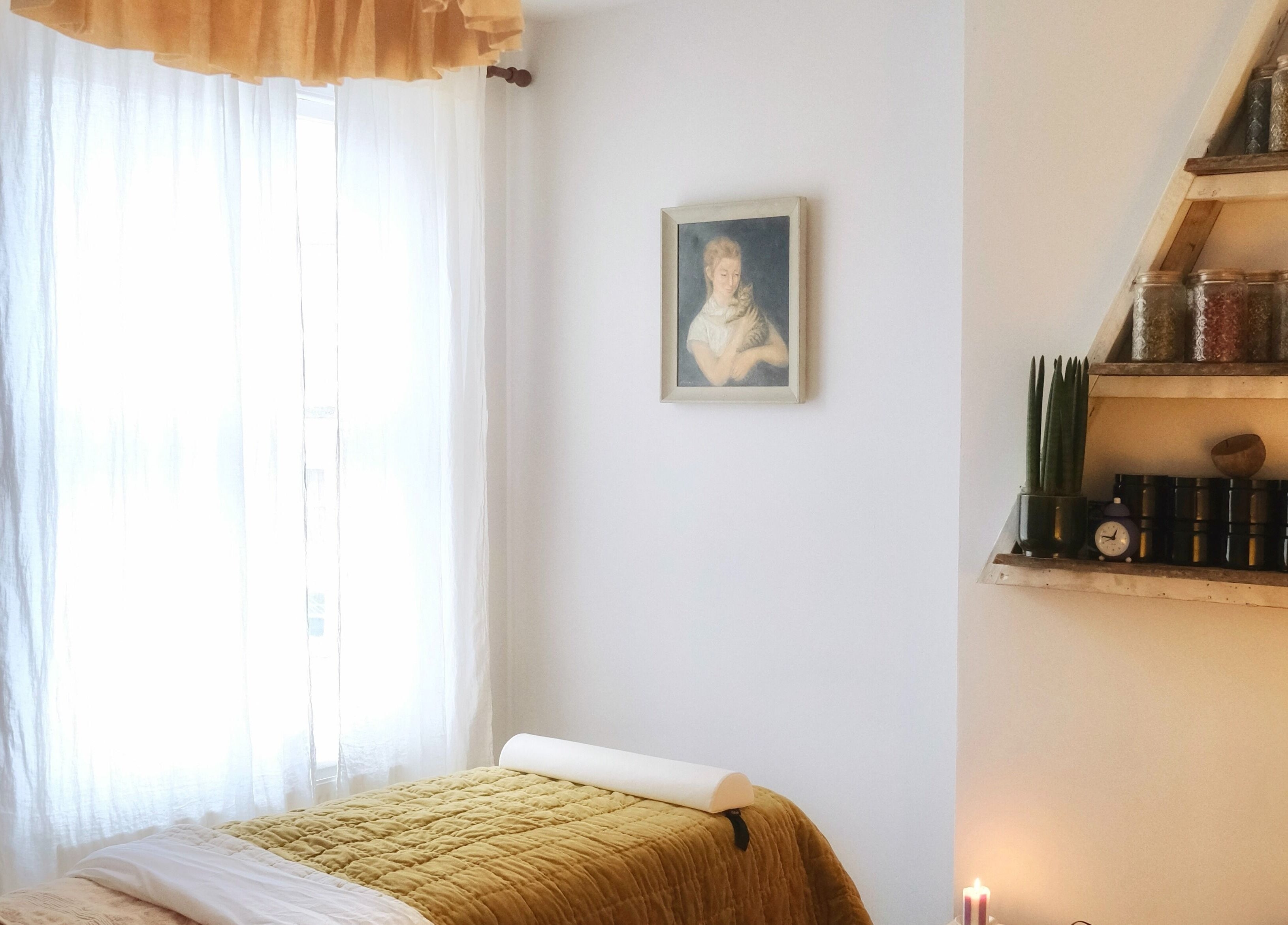 Tranquil treatment room at Spell Holistic, Saint Leonards, England, with cozy bed and herbal decor.