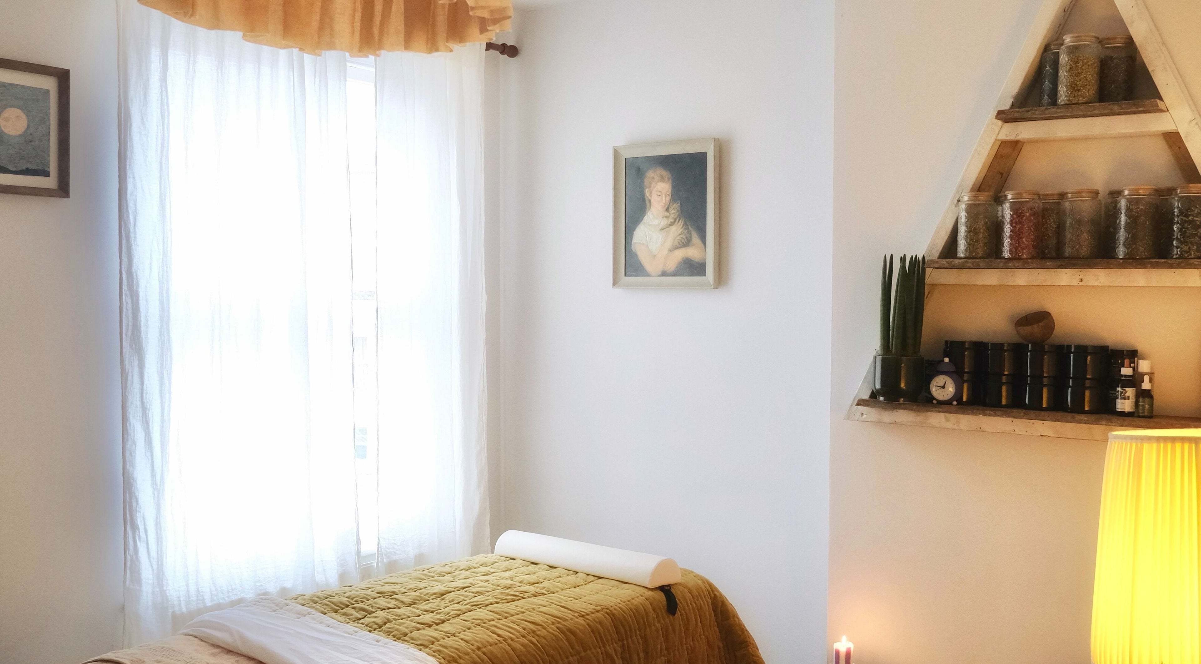Tranquil treatment room at Spell Holistic, Saint Leonards, England, with cozy bed and herbal decor.