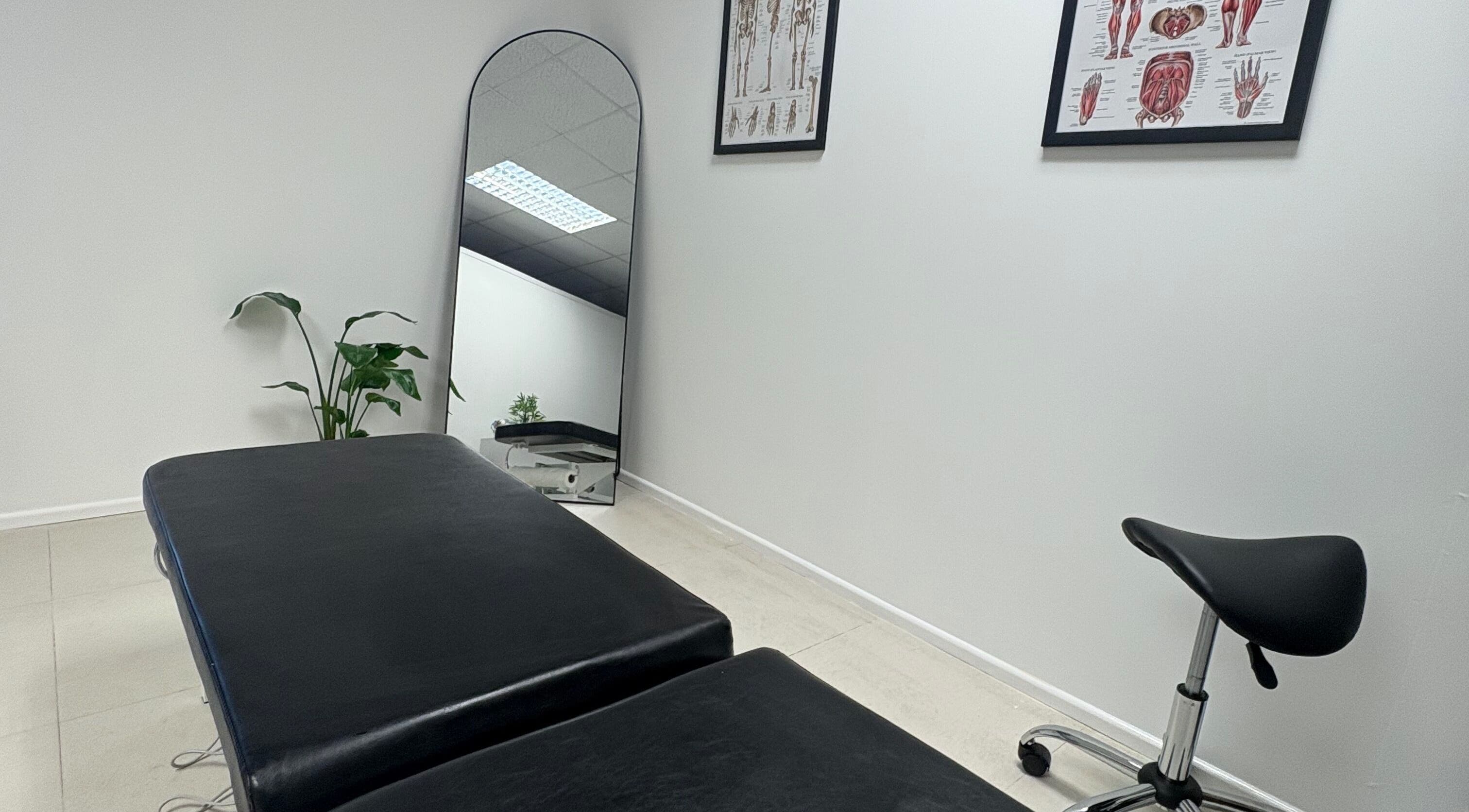 Modern therapy room at CJ Flow Wellness, Milford Haven, Wales, GB with massage table and stool.