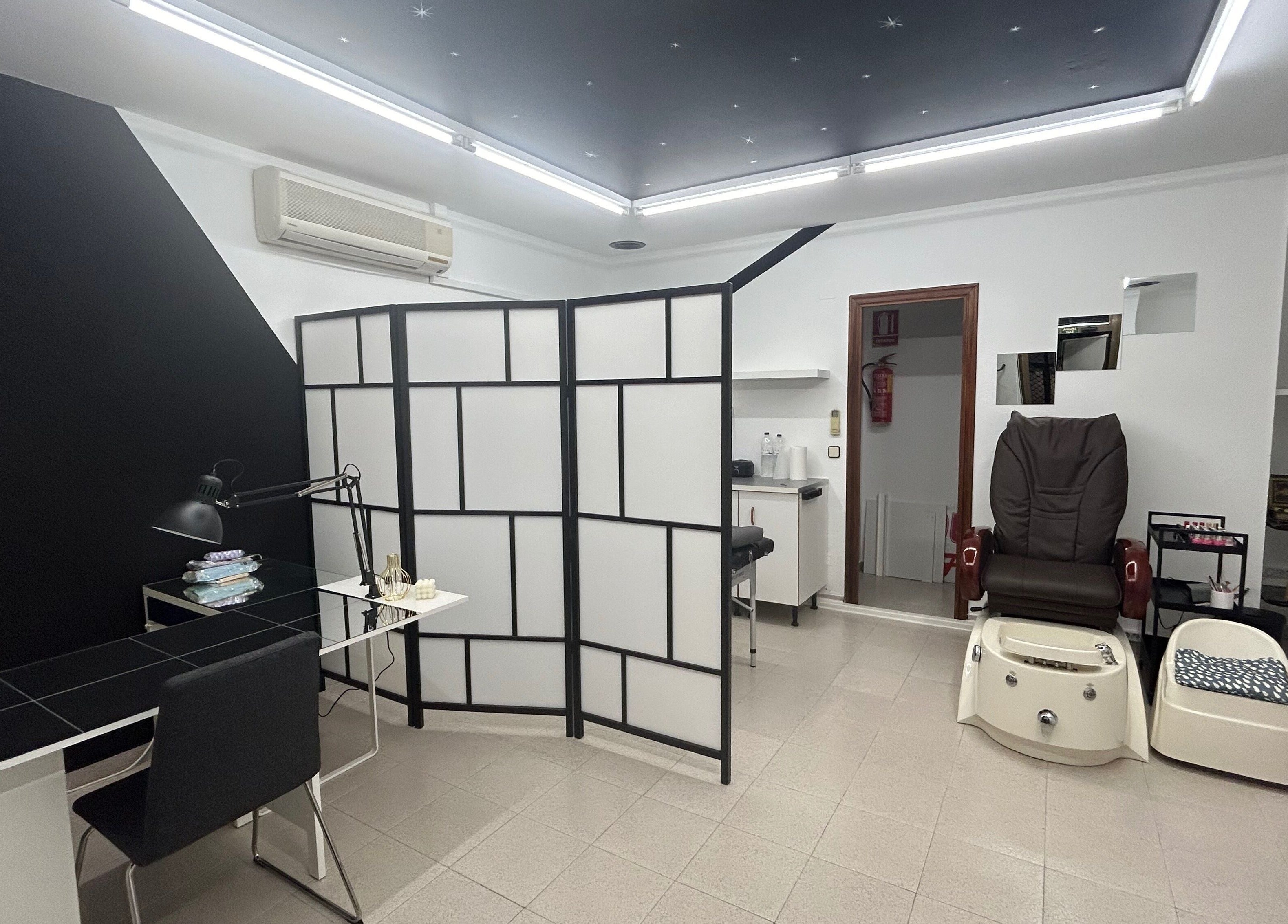 Elegante espacio en Dayana Leon, Huesca, Aragón, ES, mostrando una silla de masaje y una mesa de trabajo.