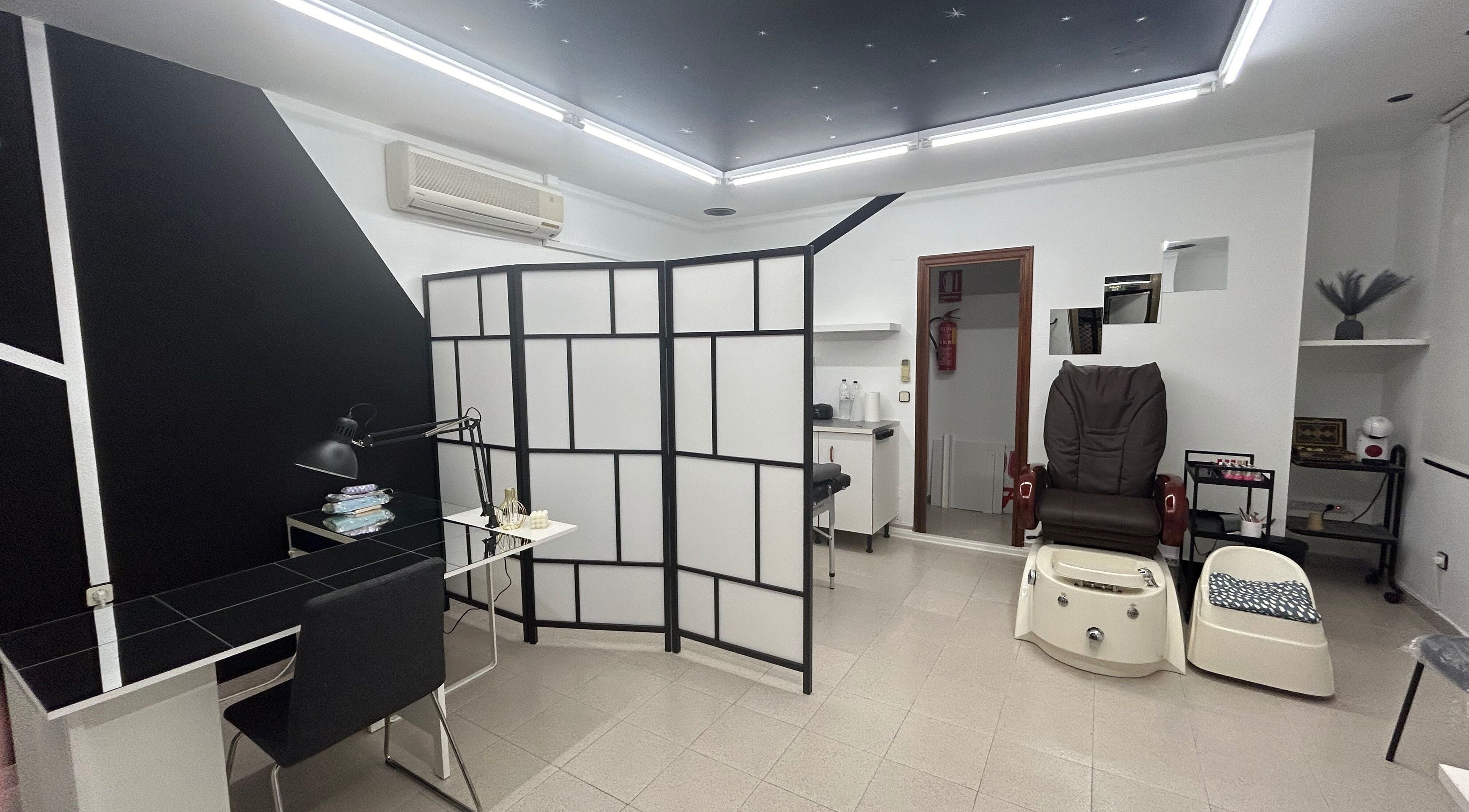 Elegante espacio en Dayana Leon, Huesca, Aragón, ES, mostrando una silla de masaje y una mesa de trabajo.