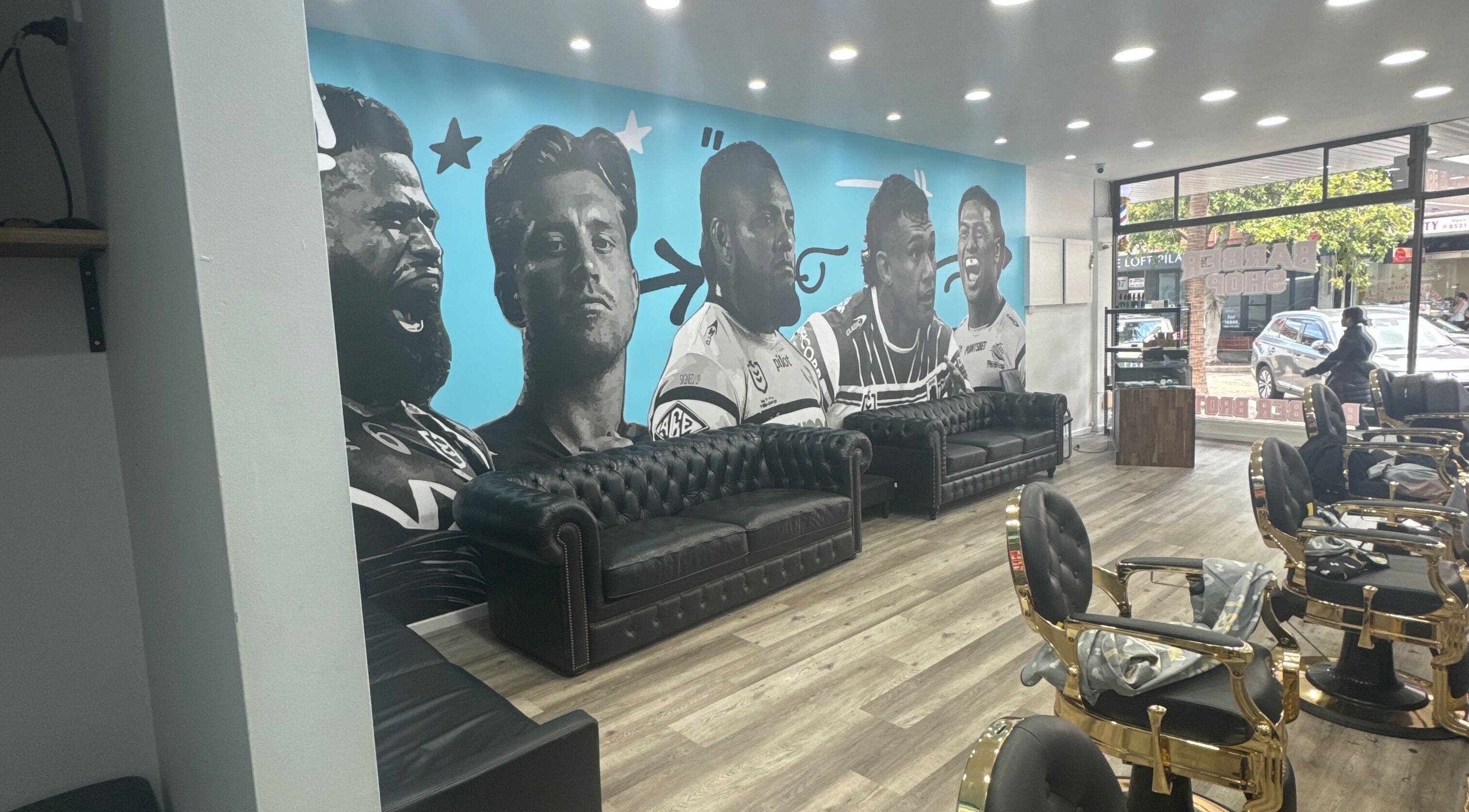 Stylish interior of Barber Brothers in Cronulla, New South Wales, AU, featuring a striking mural and plush seating.