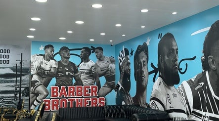 Inside Barber Brothers, Cronulla, New South Wales, AU, featuring sporty wall art and modern seating.