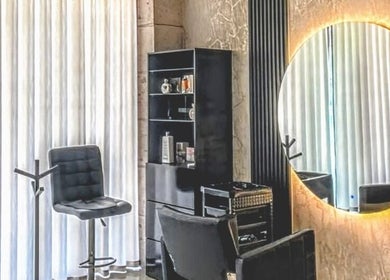 Chic salon setup at Sandra Trejos Marin, Melbourne, Victoria, AU with modern chair and round mirror.