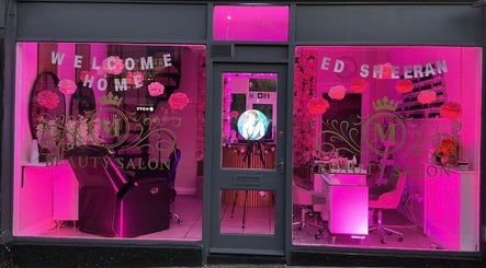 Front view of Luxe Beauty Suffolk, Ipswich, England, GB with vibrant pink lighting and salon chairs.