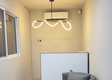 Recepción minimalista en Olivia Studio, Mérida, Yucatán, MX con lámpara moderna y ambiente acogedor.