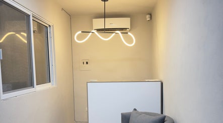 Recepción minimalista en Olivia Studio, Mérida, Yucatán, MX con lámpara moderna y ambiente acogedor.