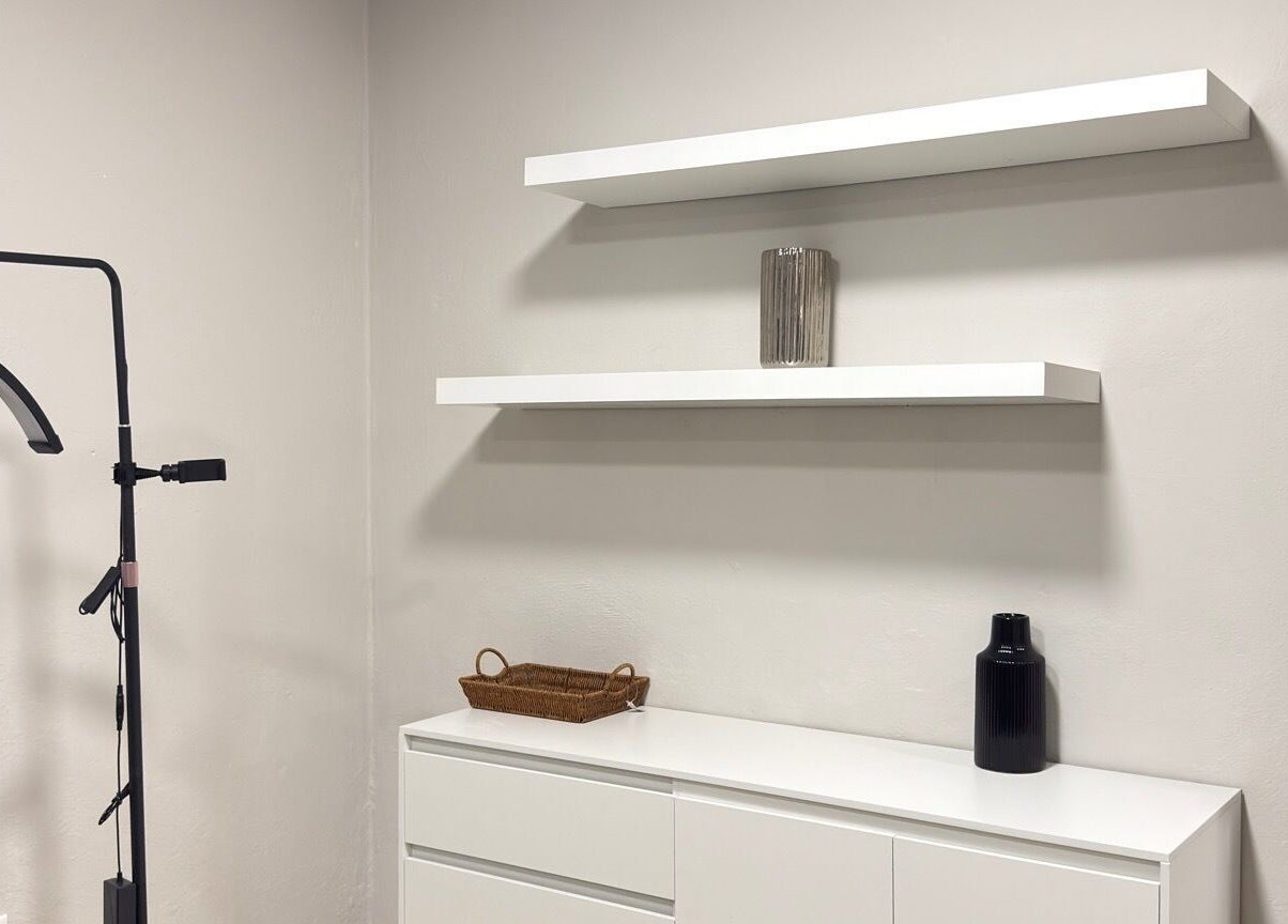 Espacio minimalista en Olivia Studio, Mérida, Yucatán, MX, con estantes blancos y decoración moderna.