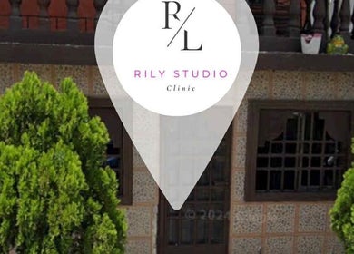 Exterior view of RILY STUDIO Clinic in Nuevo Laredo, Tamaulipas, MX with lush greenery and elegant design.