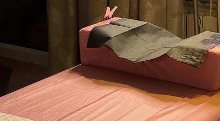 Relaxing treatment bed at The Lash Fairy, Katowice, Województwo Śląskie, PL with soft pink and gray tones.