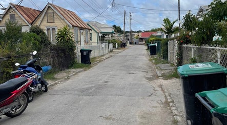 Street view near Nya_nailluxury, Bridgetown, Saint Michael, BB, showcasing local architecture and greenery.