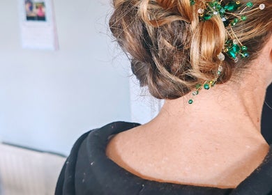 Elegant updo hairstyle with green gemstone accents at Faces of Angels in Hartlepool, England, GB.