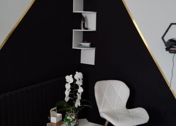 Stylowy kącik w Talima, Piaseczno, Województwo Mazowieckie, PL z białym fotelem i rośliną.