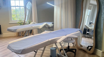 Calming treatment room at Rebecca Slane Skin, Alderley Edge, England, GB. Featuring spa beds and mirrors.