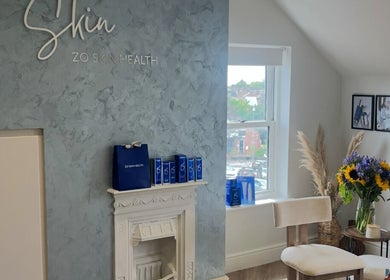 Cozy room at Rebecca Slane Skin, Alderley Edge, England featuring elegant decor and vibrant flowers.