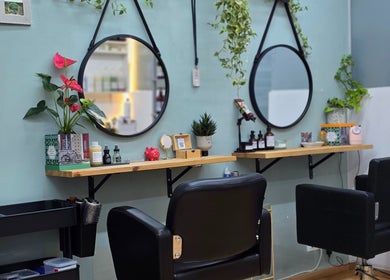 Sala moderna en GABO LLOJA HAIR SALÓN AND BEAUTY en Barcelona, Catalunya, ES con espejos redondos y plantas decorativas.