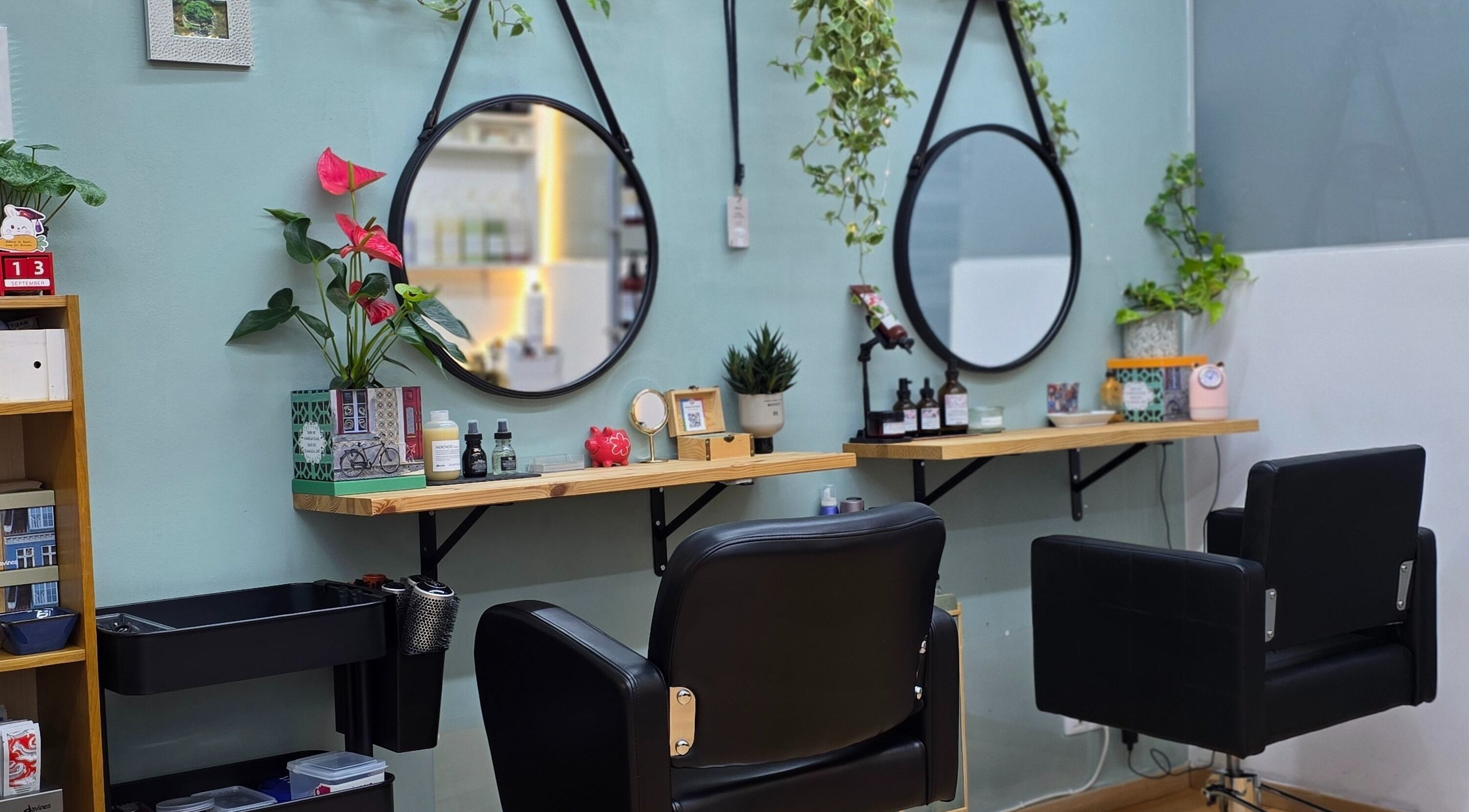 Sala moderna en GABO LLOJA HAIR SALÓN AND BEAUTY en Barcelona, Catalunya, ES con espejos redondos y plantas decorativas.