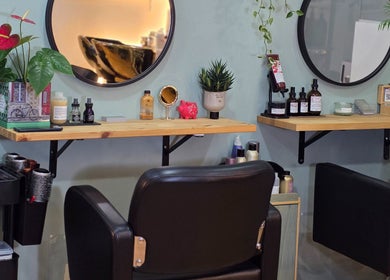 Interior acogedor de GABO LLOJA HAIR SALÓN AND BEAUTY en Barcelona, Catalunya, ES con sillas y espejos elegantes.