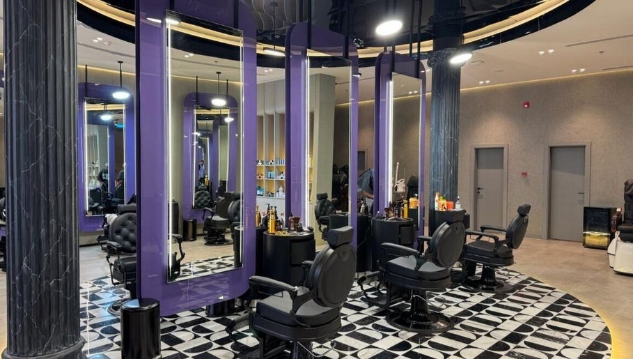 Sophisticated interior of Al Alami Barbershop العالمي in Jeddah, Makkah Province, SA with modern black chairs.