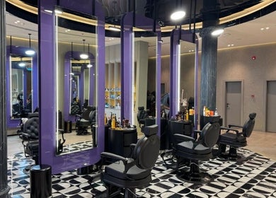 Sophisticated interior of Al Alami Barbershop العالمي in Jeddah, Makkah Province, SA with modern black chairs.