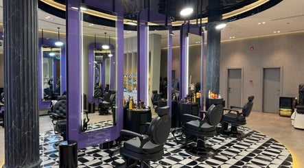 Sophisticated interior of Al Alami Barbershop العالمي in Jeddah, Makkah Province, SA with modern black chairs.