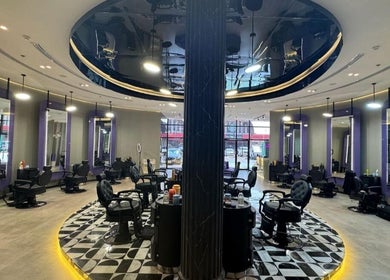 Spacious interior of Al Alami Barbershop العالمي, Jeddah, Makkah Province, SA featuring chic styling stations.