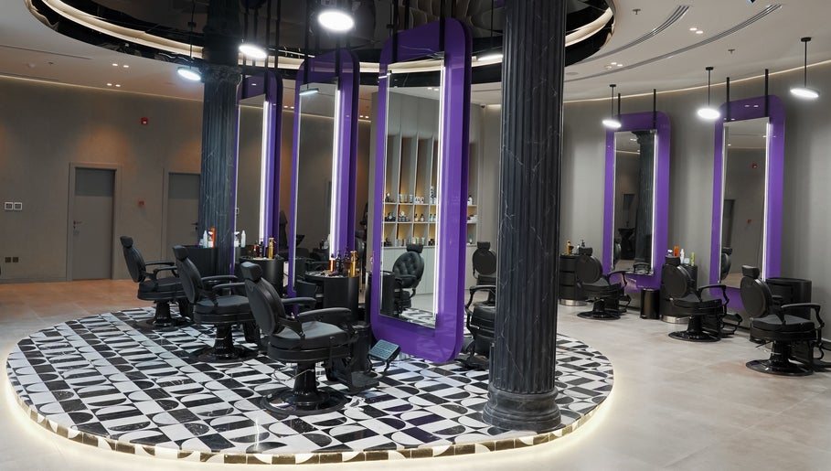 Modern interior of Al Alami Barbershop العالمي in Jeddah, Makkah Province, SA featuring elegant purple mirrors.