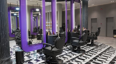 Modern interior of Al Alami Barbershop العالمي in Jeddah, Makkah Province, SA featuring stylish barber chairs.