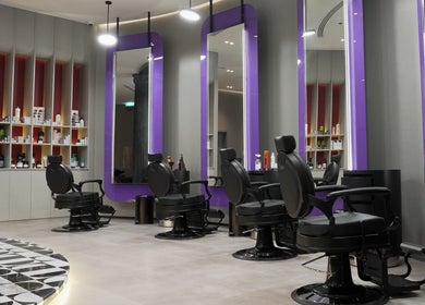 Modern interior of Al Alami Barbershop العالمي in Jeddah, Makkah Province, SA, featuring stylish chairs and mirrors.
