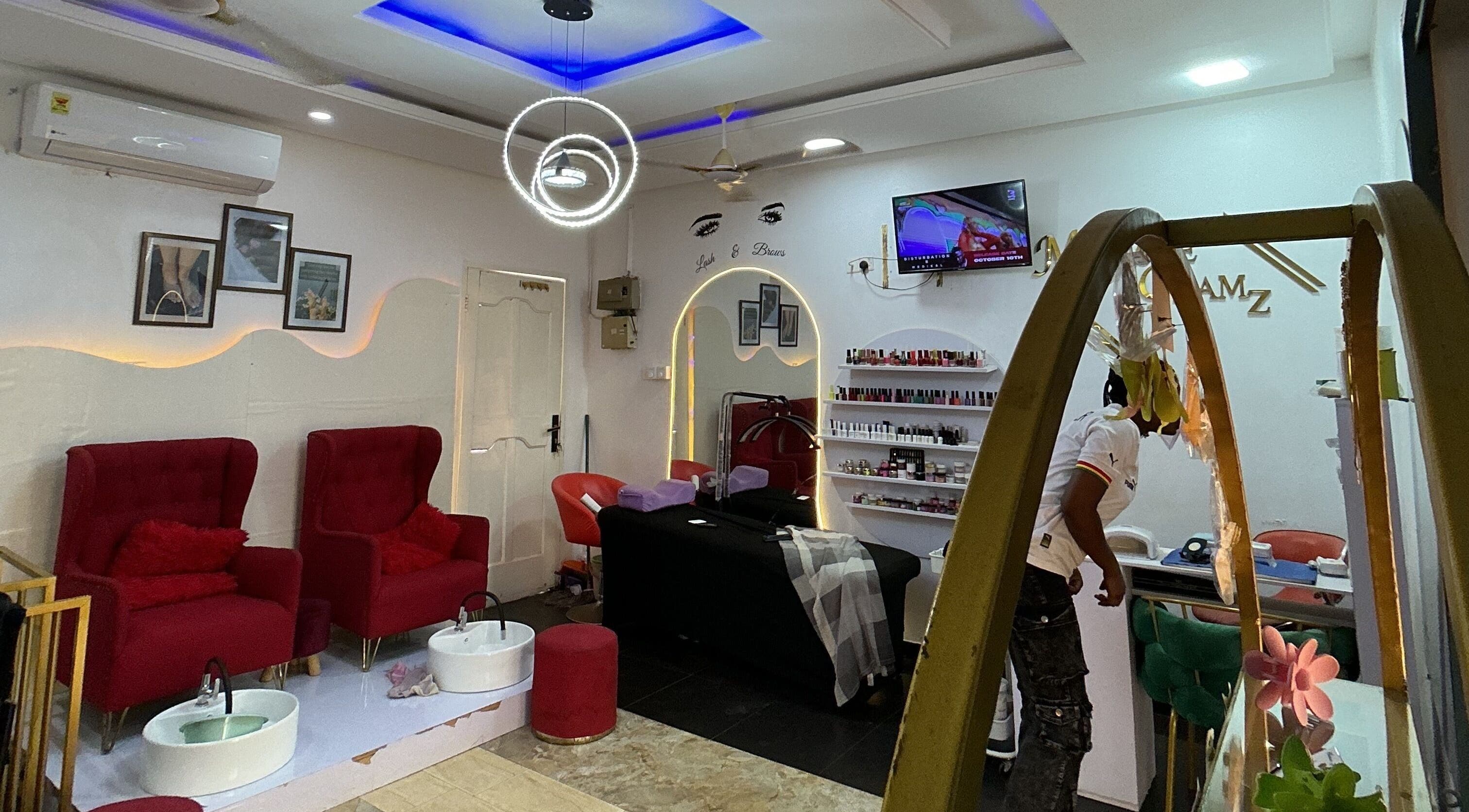 Elegant salon interior at Millsheglamz, Greater Accra Region, GH with plush red chairs and beauty products display.