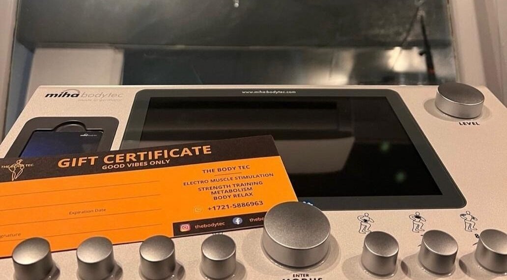 Gift certificate and device at The Body Tec, Bushroad, SX showcasing muscle stimulation services.
