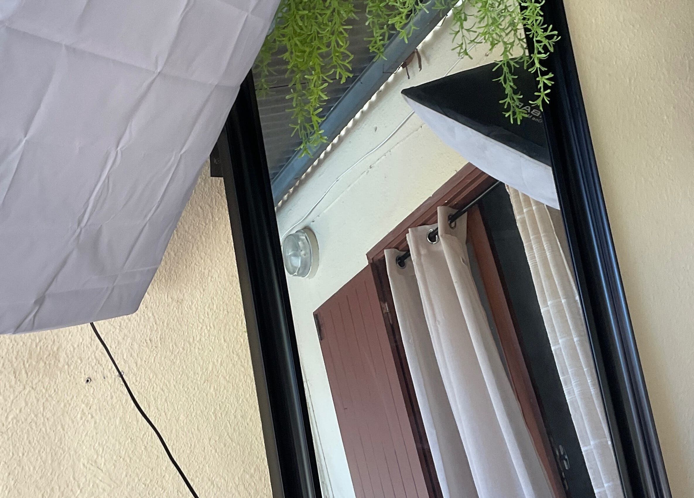 Élégance de DAMCEY à Saint-benoît, RE, avec miroir et rideaux blancs encadrés par un éclairage professionnel.