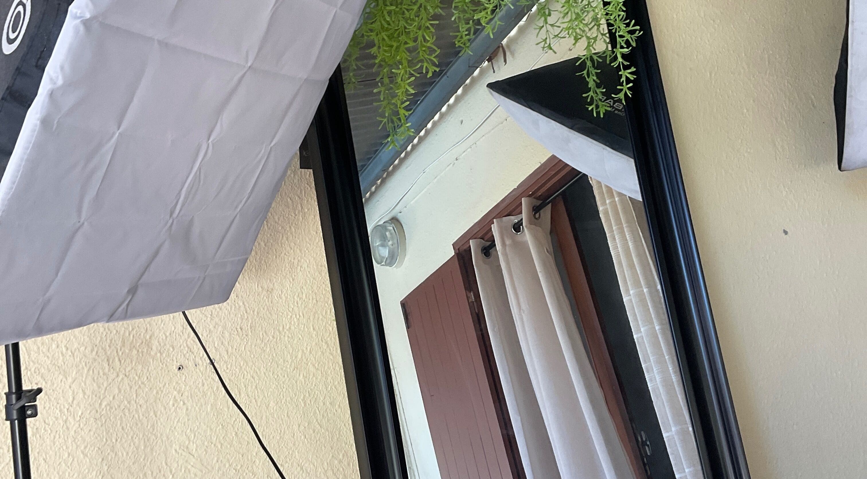 Élégance de DAMCEY à Saint-benoît, RE, avec miroir et rideaux blancs encadrés par un éclairage professionnel.