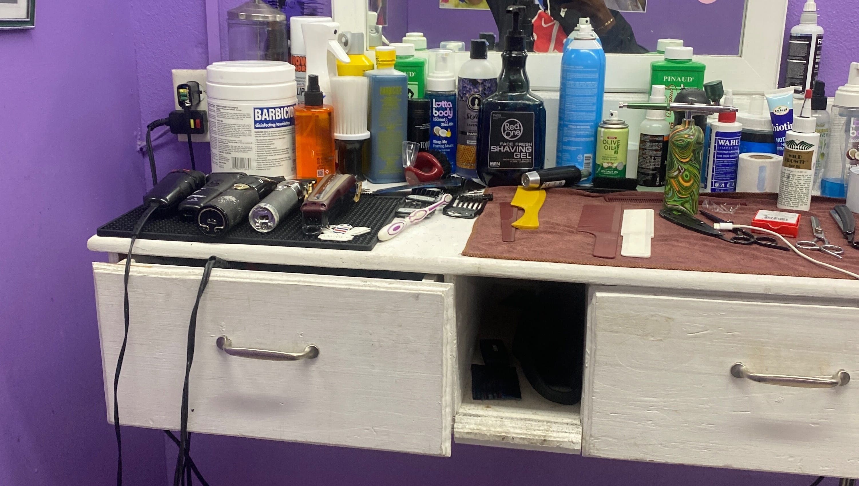 Hair styling tools and products on a counter at Dre Cool Cutz, Nassau, New Providence, BS.