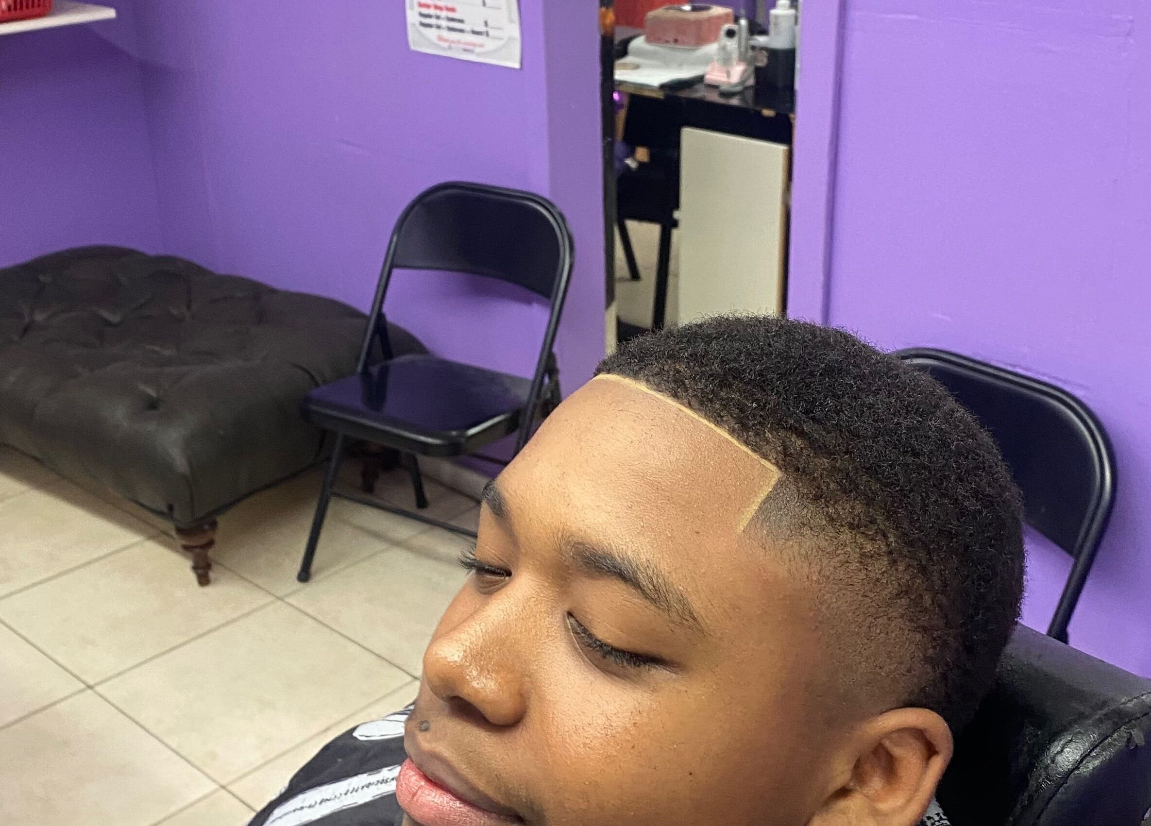 Close-up of a fresh fade haircut at Dre Cool Cutz, Nassau, New Providence, BS purple interior.