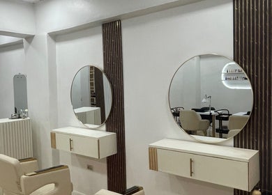 Interior elegante de Moon Beauty en Valencia, Carabobo, VE con espejos circulares y sillones de diseño.