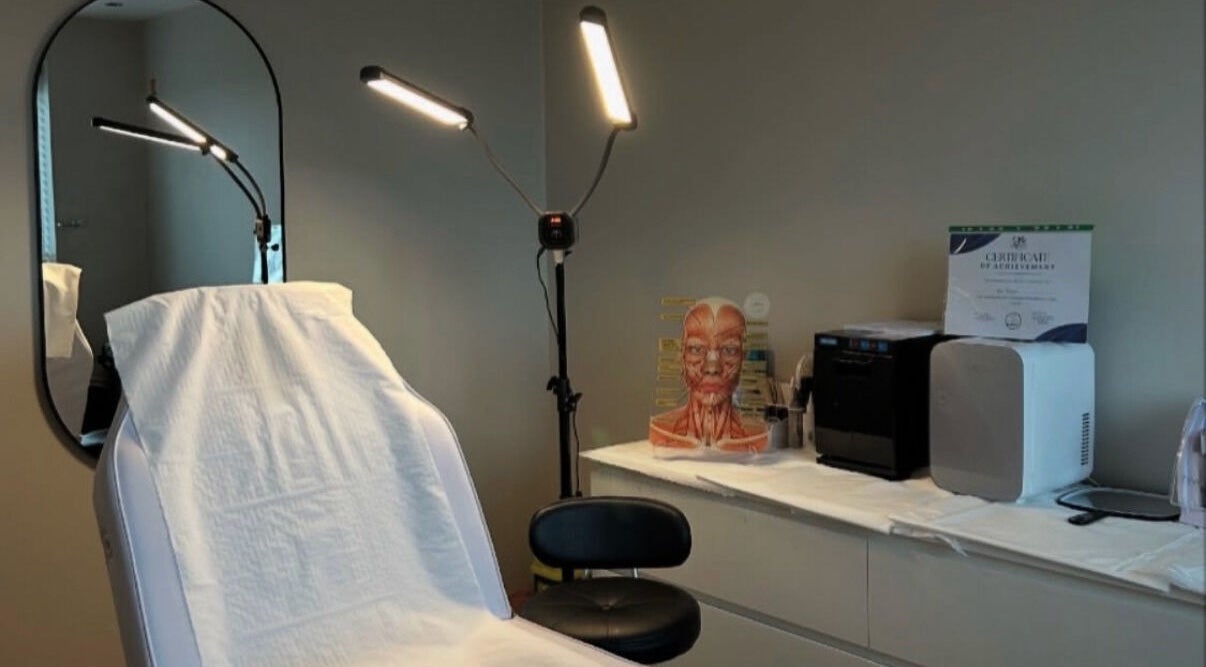 Modern treatment room at The Beauty Bar Swansea, Llansamlet, Wales, GB, with chair, mirror, and lighting.