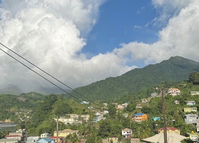 Scenic view from _Braided.by_bri, Kingstown, St. David, VC with lush green hills and colorful homes.