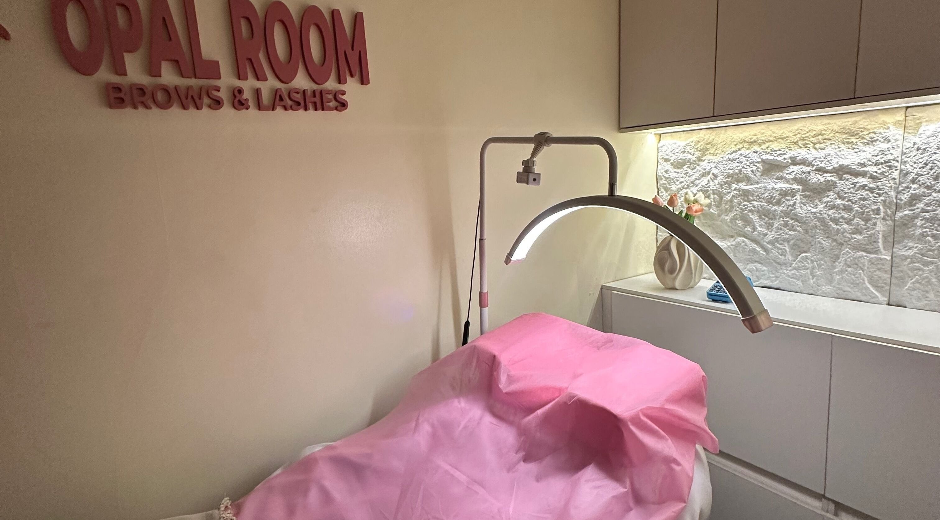 Opalroom spa treatment space in Lagos, Lagos, NG, featuring a pink-covered treatment bed with stylish decor.