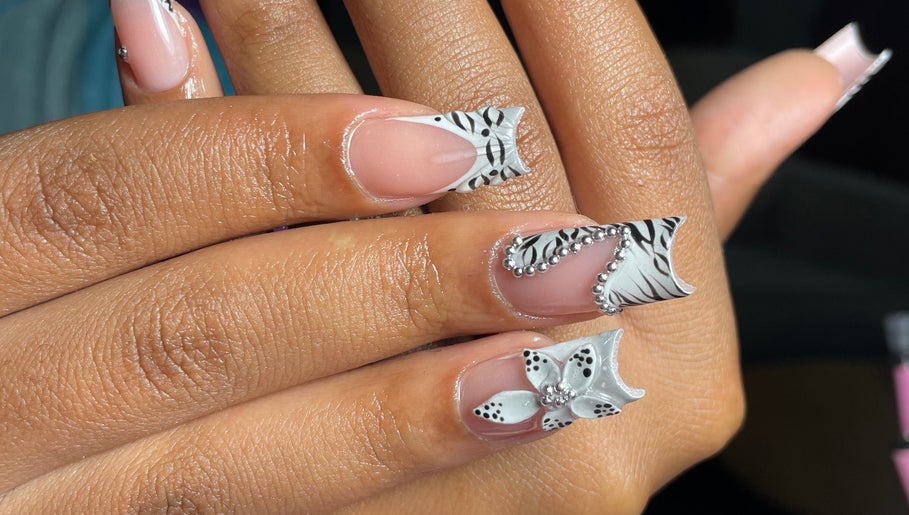 Elegant zebra pattern nails with floral design at Luxe Beautefix, Manhattan, Kansas, US.