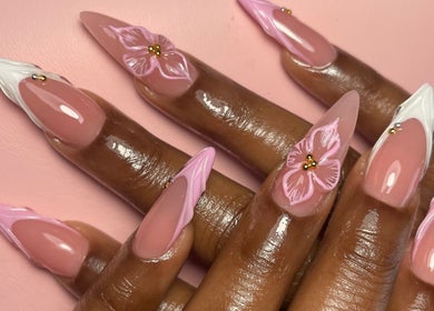 Beautiful floral nail art at Luxe Beautefix, Manhattan, Kansas, US. Detailed pink and white designs.