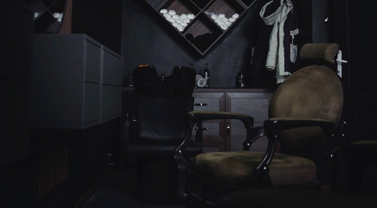 Cozy interior of Vibes Barbería in Beograd, RS with vintage barber chairs.