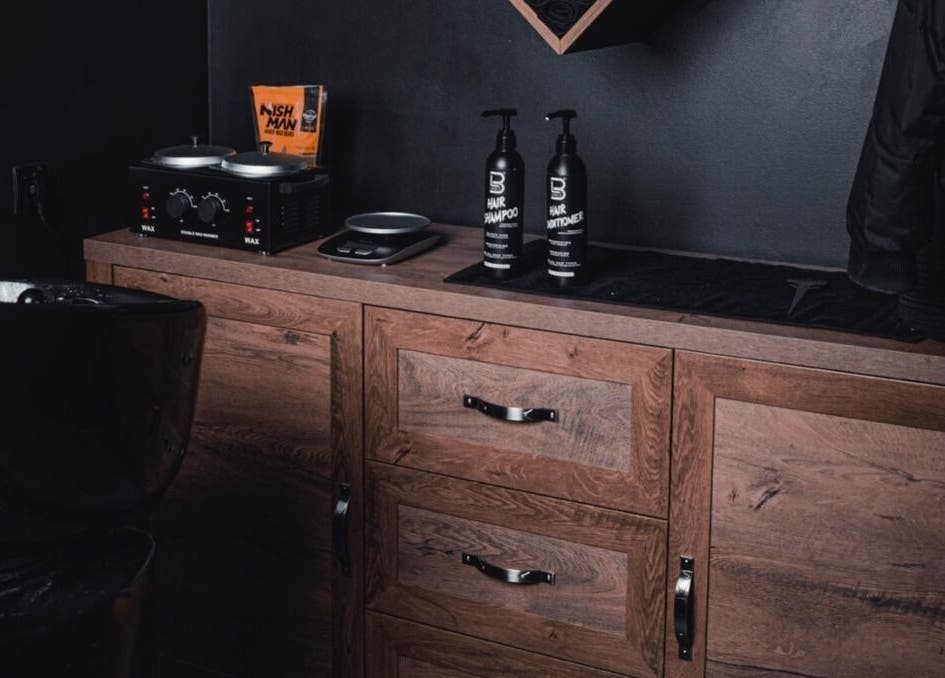 Vibes Barbería's sleek styling station in Beograd, RS with premium products and wooden cabinetry.