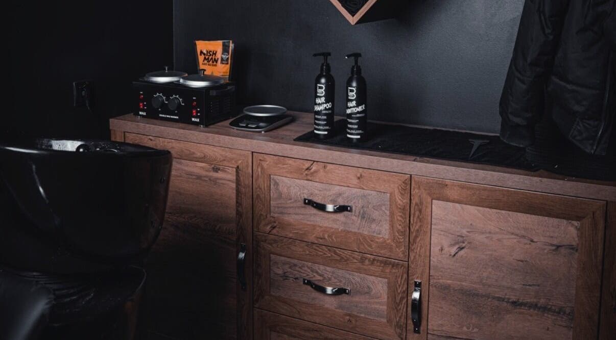 Vibes Barbería's sleek styling station in Beograd, RS with premium products and wooden cabinetry.