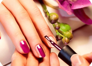 Manicure session at Rapha Wellness, Johannesburg, Gauteng, ZA showcasing vibrant pink nails and floral decor.
