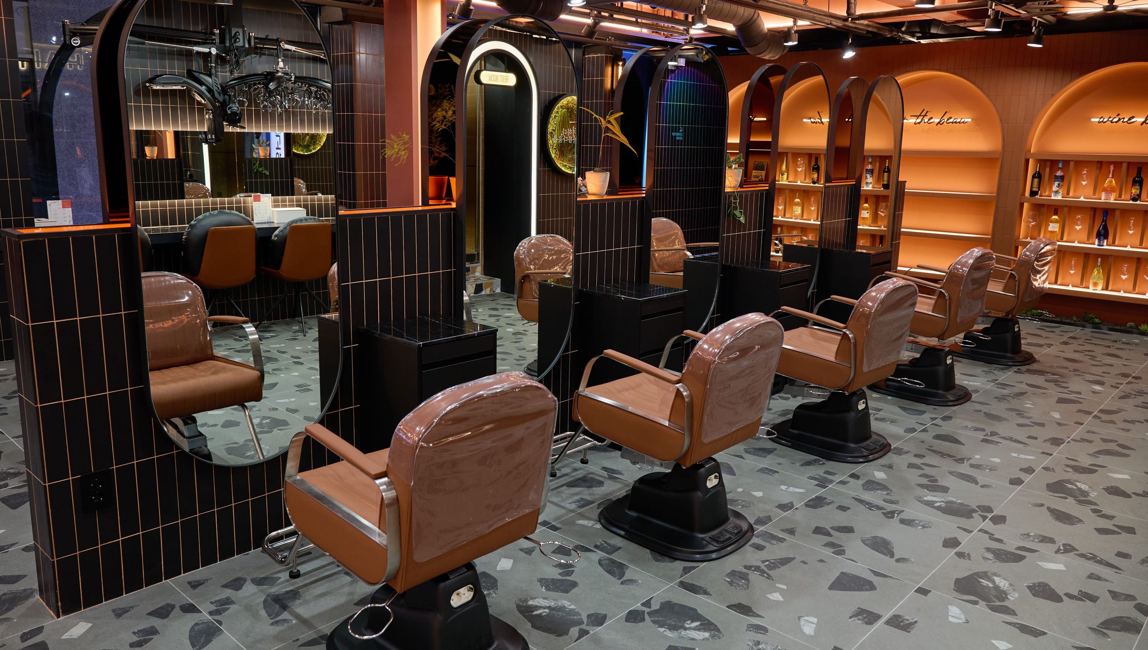 Stylish interior of Hair The Beau Myeongdong in 서울특별시 with modern salon chairs and mirrors.