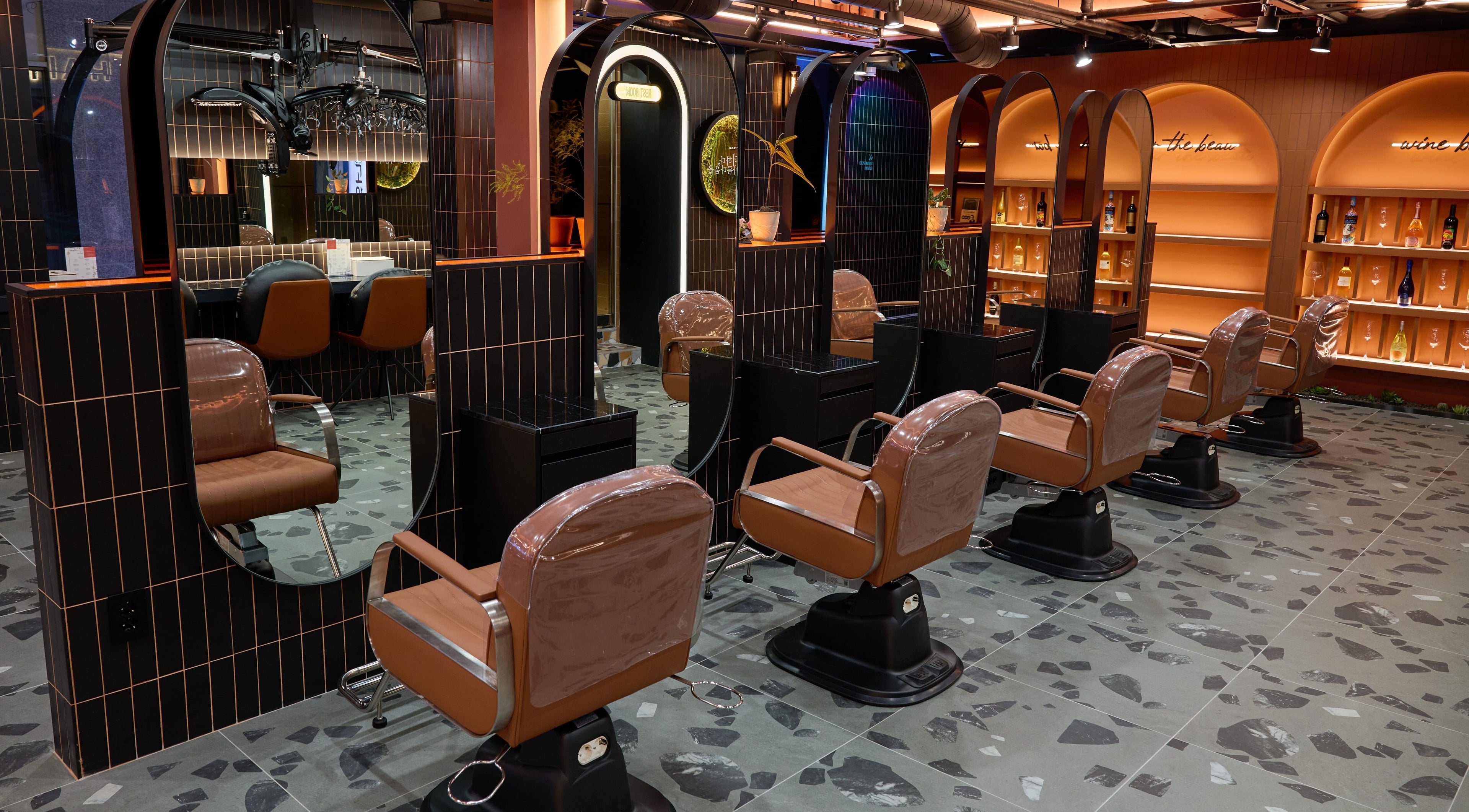 Stylish interior of Hair The Beau Myeongdong in 서울특별시 with modern salon chairs and mirrors.
