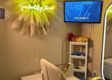 Cozy salon chair with neon TouchedByChanel sign in Montréal, Québec, CA.